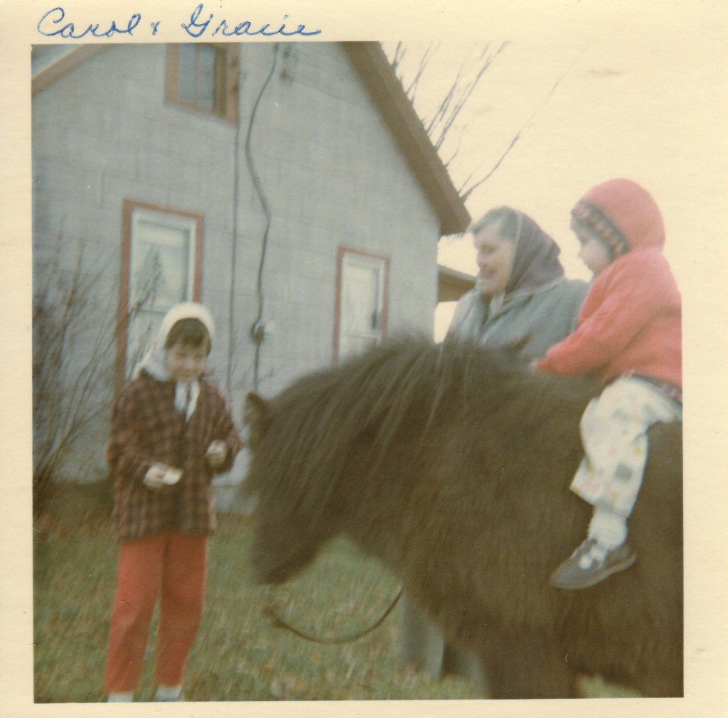 Grandma, I am standing and my sister is on the pony